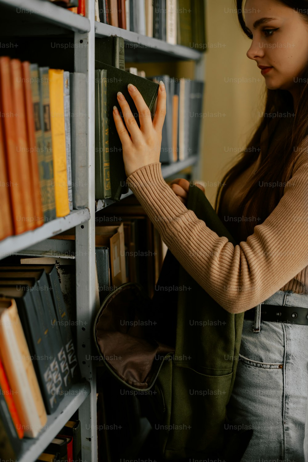 a woman is looking at books on a book shelf