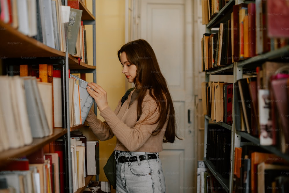 uma mulher está olhando para um livro em uma biblioteca