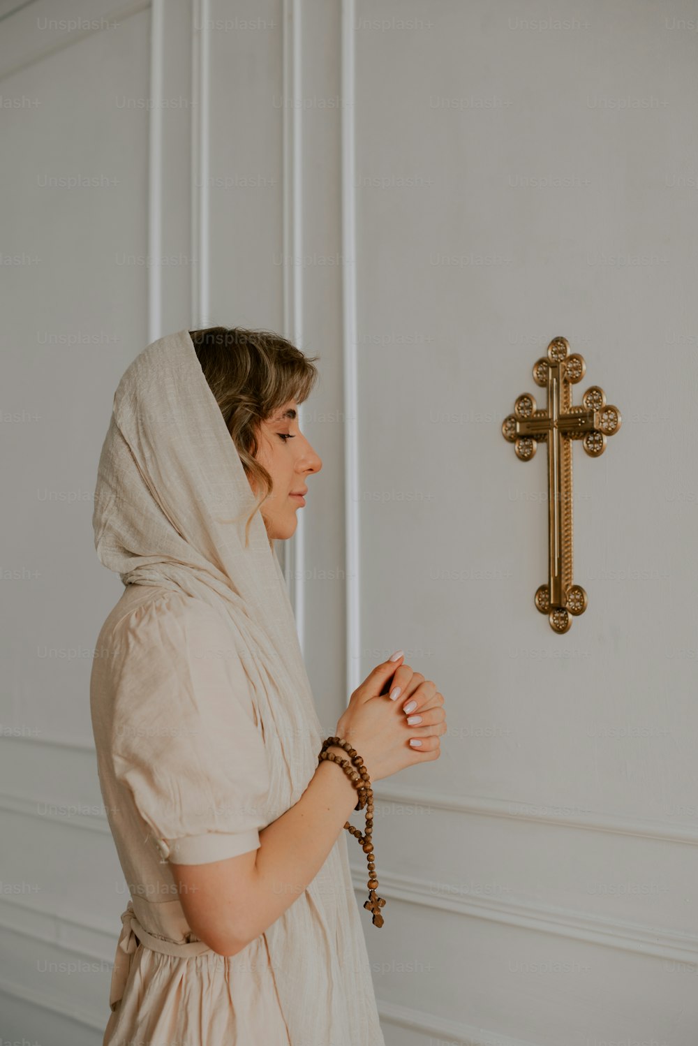 Una mujer parada frente a una cruz