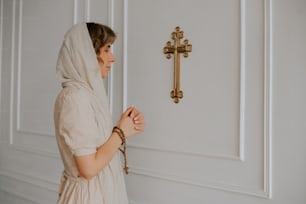 uma mulher em frente a uma porta com uma cruz sobre ela