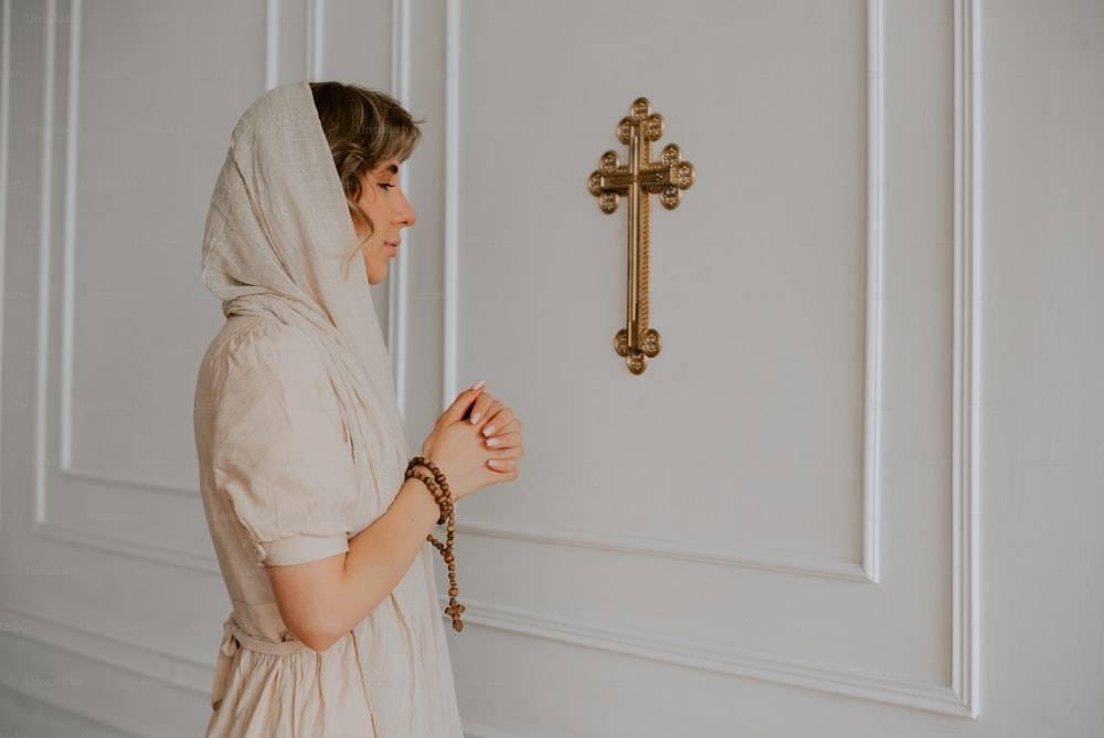 Una mujer parada frente a una puerta con una cruz en ella