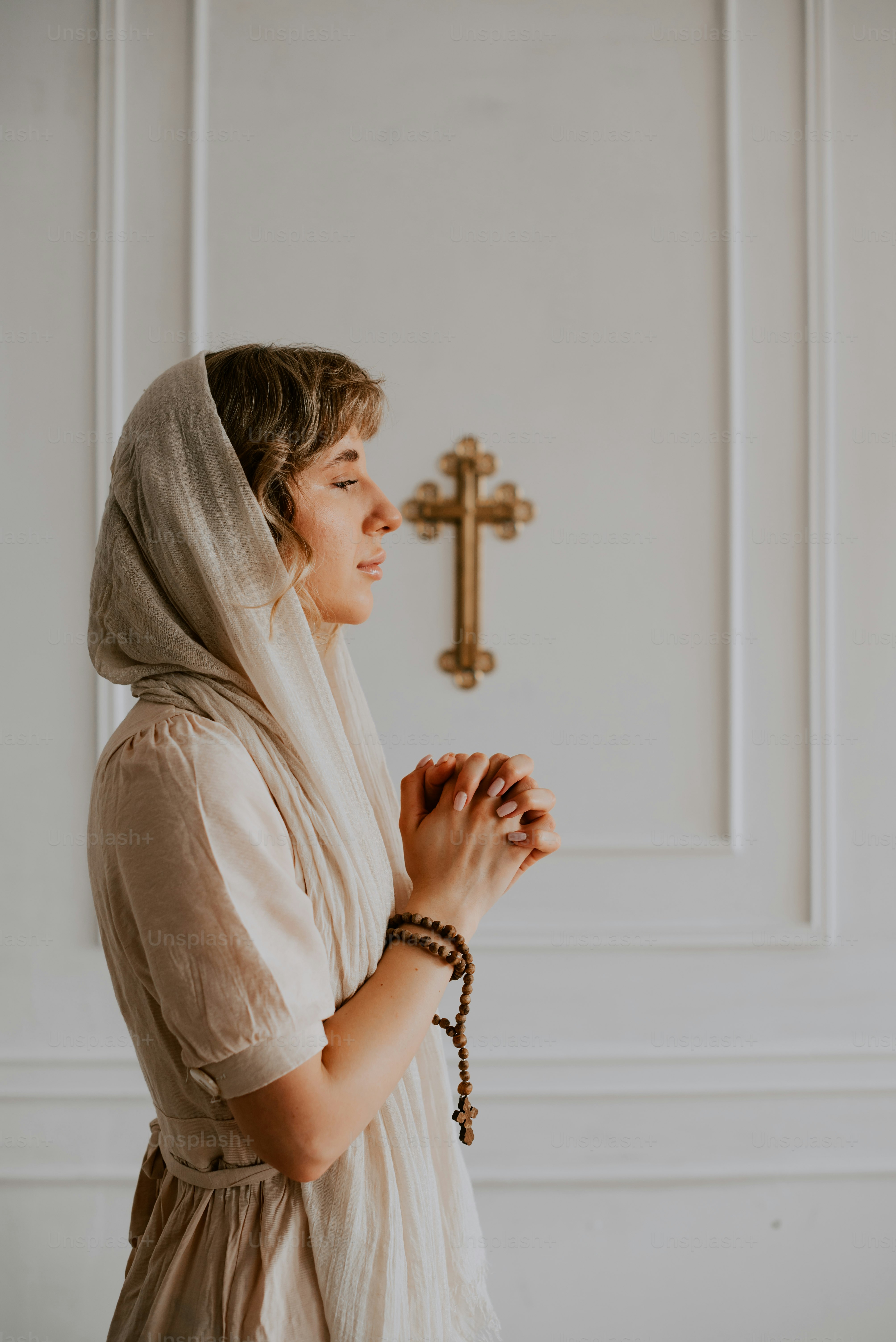 a woman wearing a veil and holding a rosary