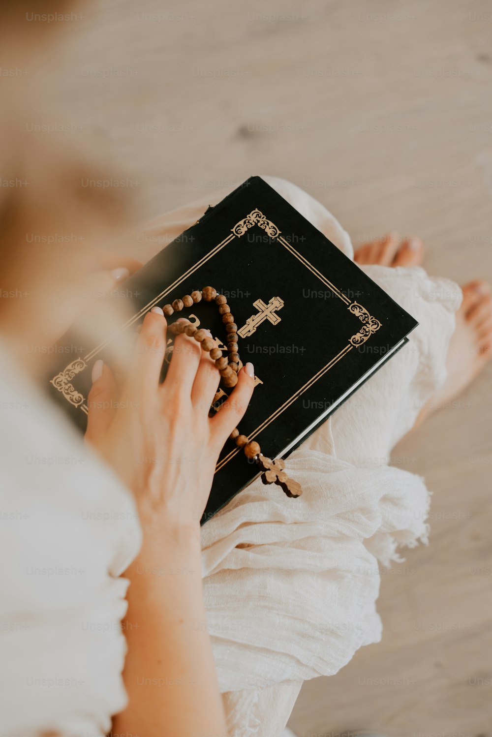 a woman holding a bible and a rosary