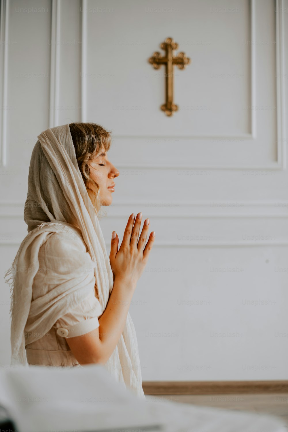 Una mujer con una túnica blanca está rezando