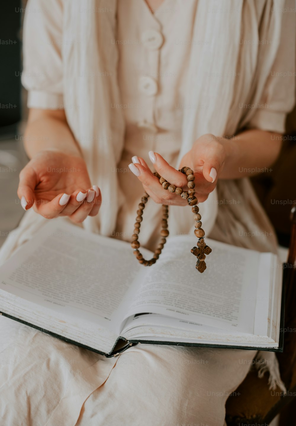 a woman holding a rosary and a book