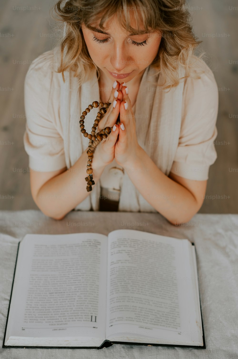 a woman sitting at a table with an open book