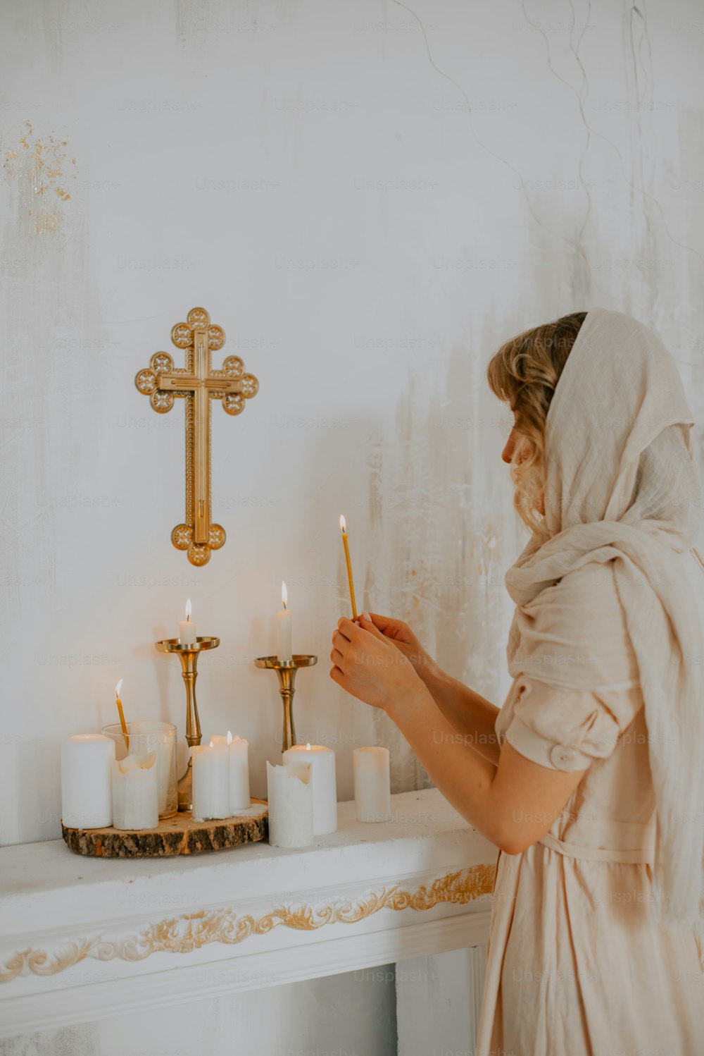 a woman in a white robe lighting candles