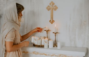 uma mulher em um véu acendendo velas em um manto