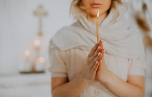 uma mulher segurando uma vela nas mãos
