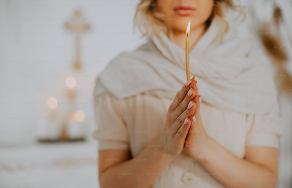 a woman holding a candle in her hands