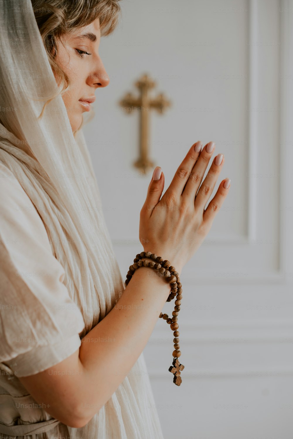 a woman wearing a veil and holding a rosary
