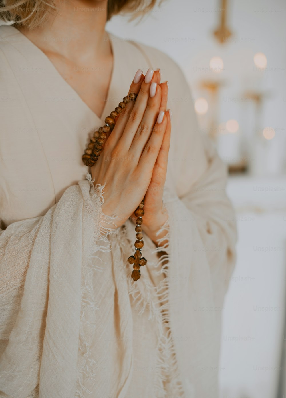 a woman in a white dress holding her hands together