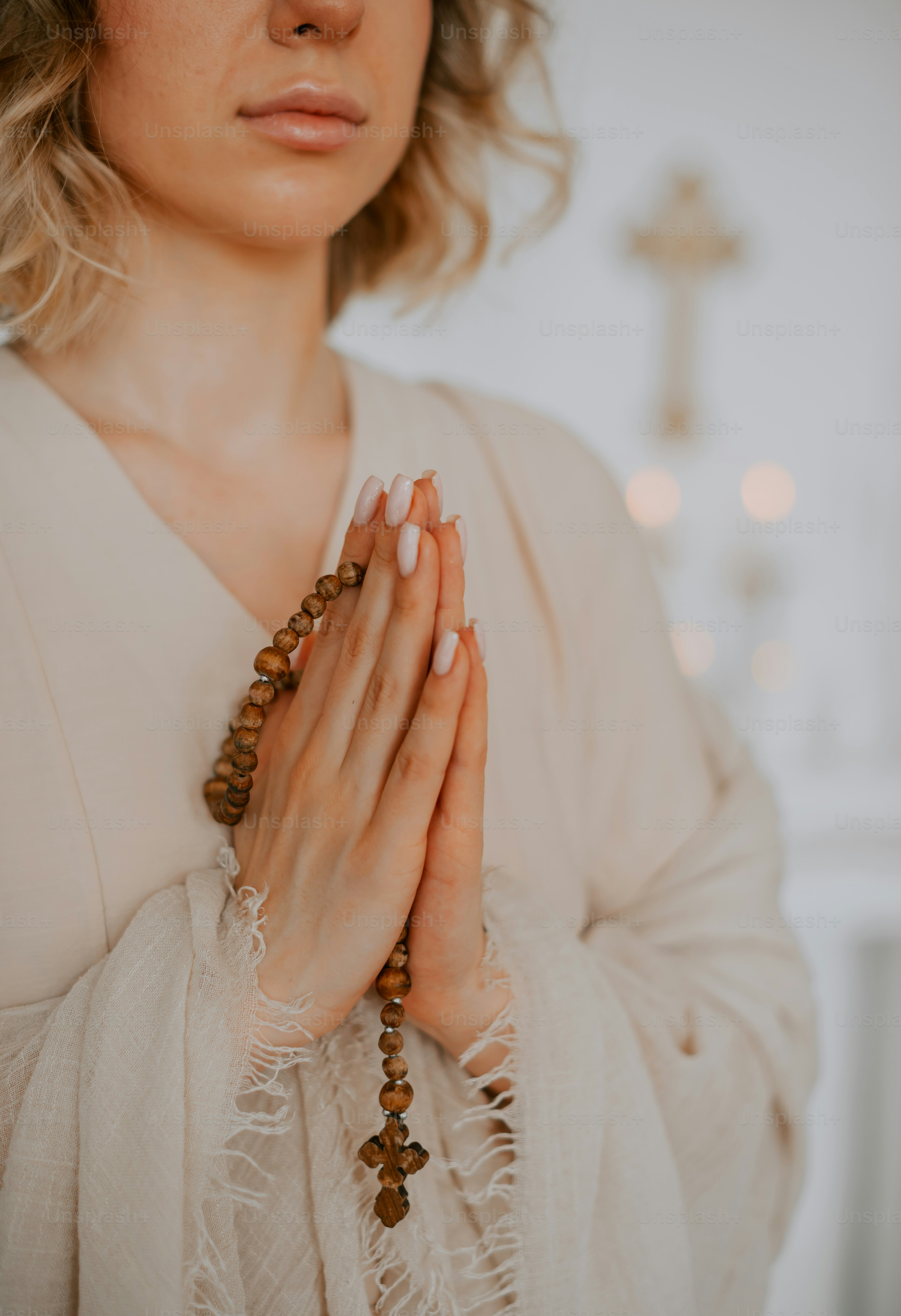una donna in un vestito bianco che tiene le mani unite