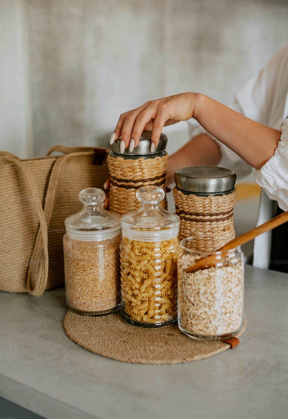 Una donna che mette un cucchiaio in un barattolo di cereali