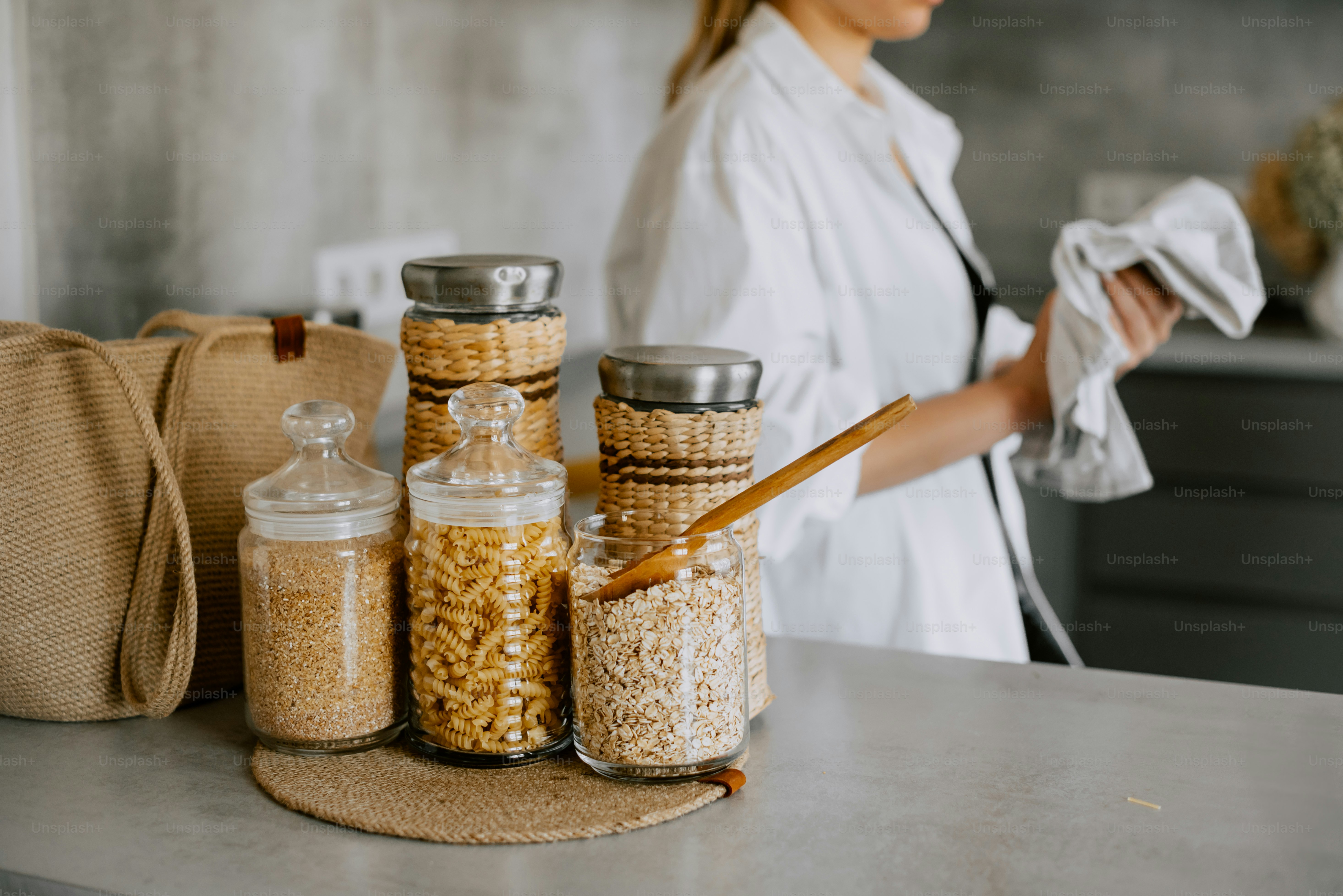 a woman standing in front of jars filled with cereal