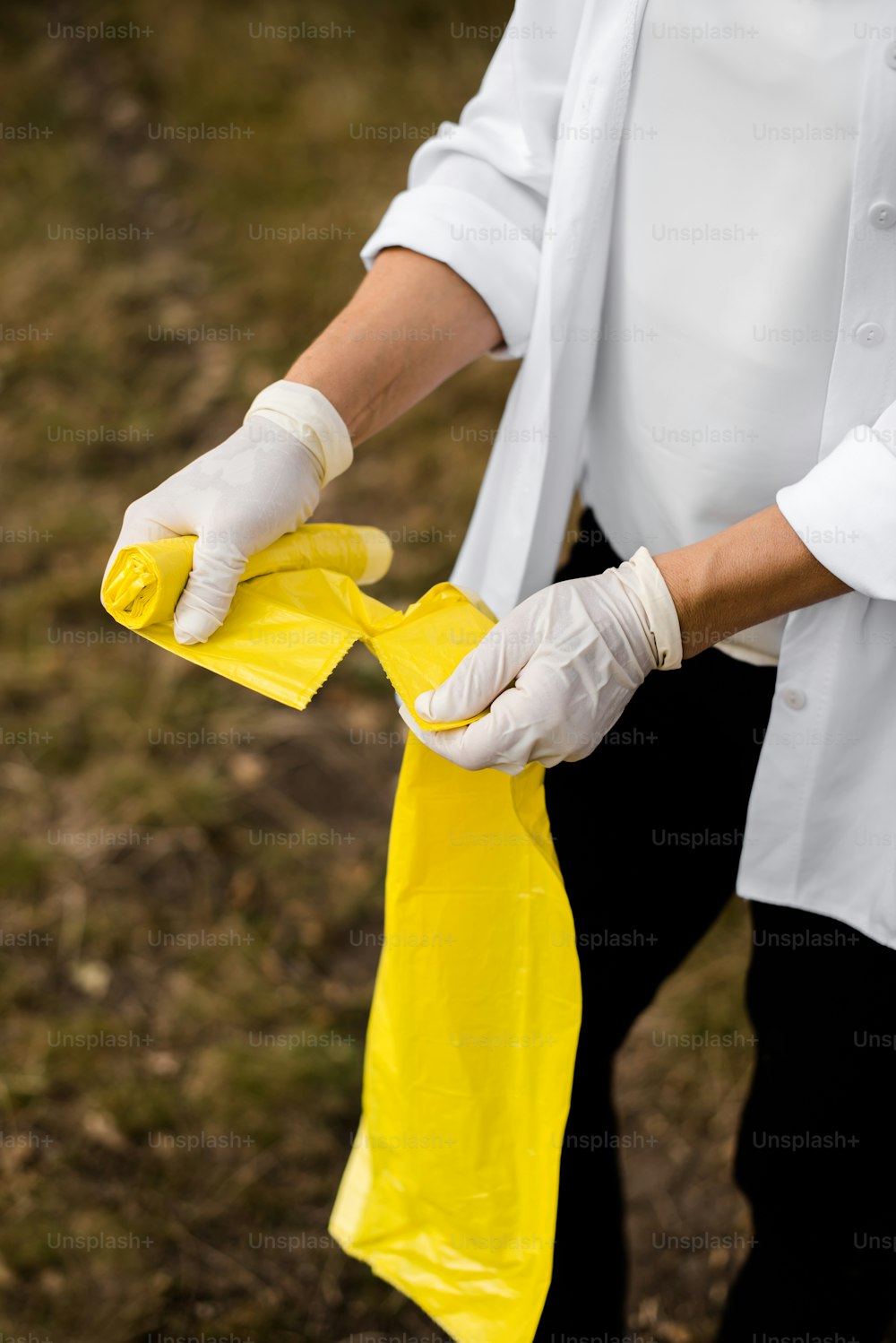 a person in a white shirt is holding a yellow bag