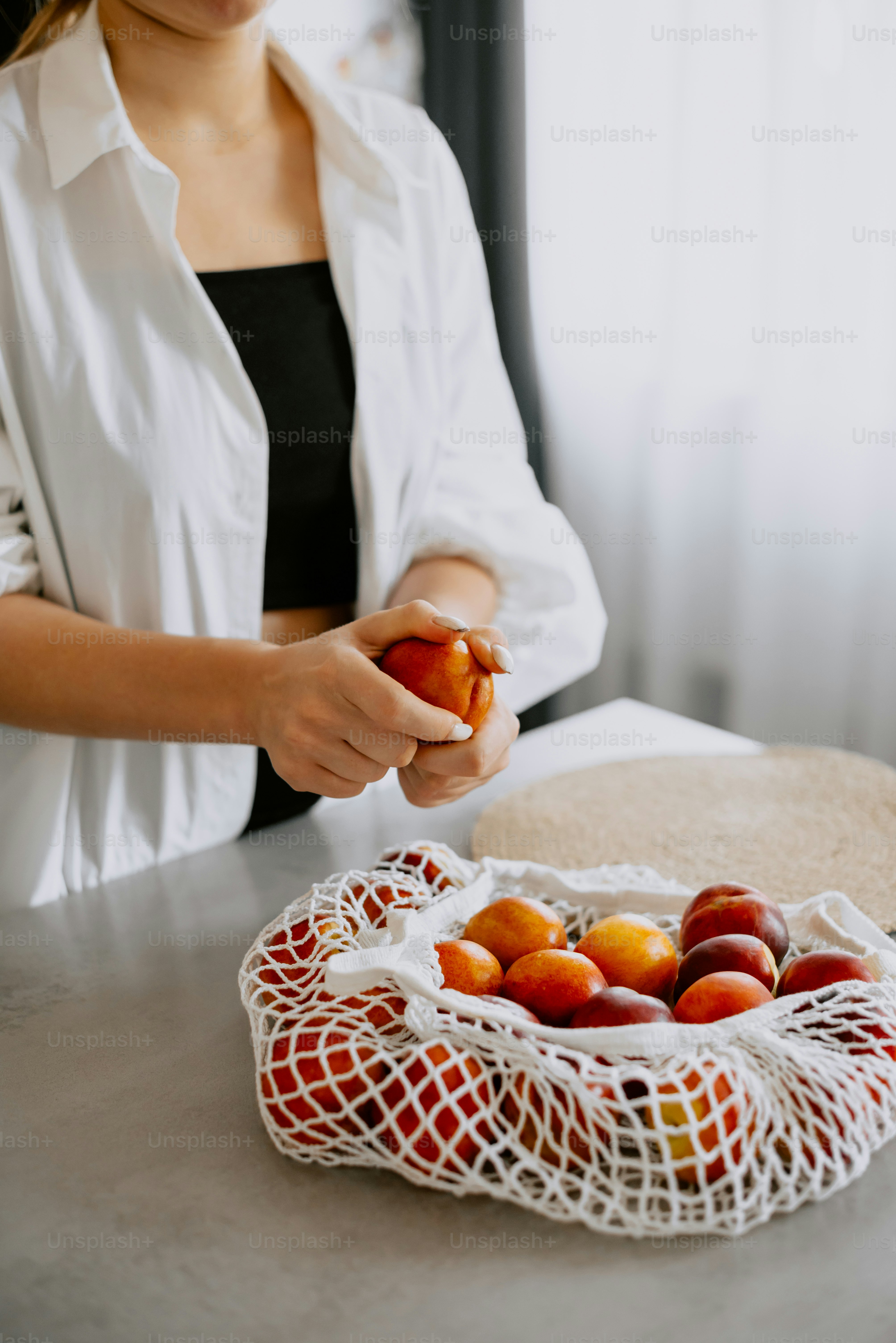 a woman holding a piece of fruit in her hand
