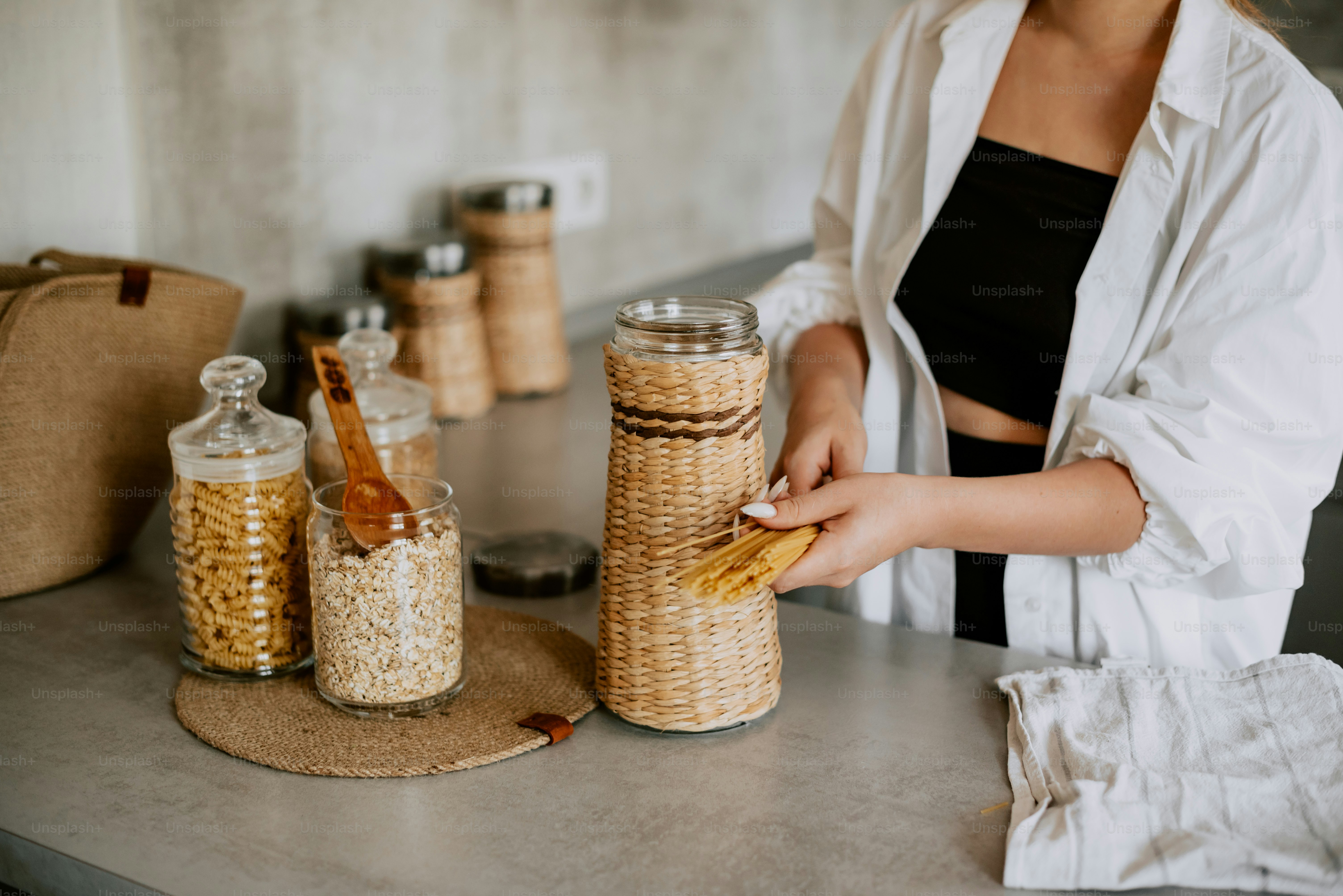 a woman standing in front of jars filled with food