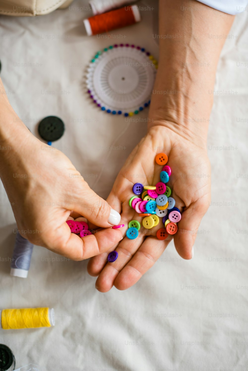 a person holding a handful of buttons in their hands