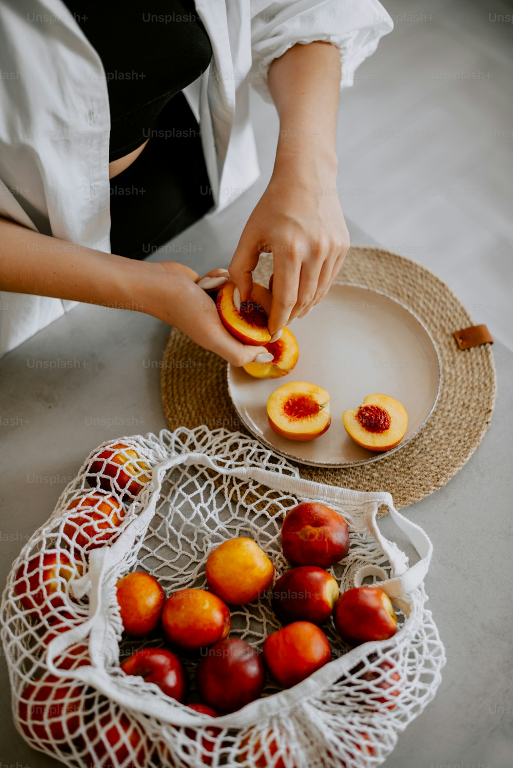 a woman is peeling peaches on a plate