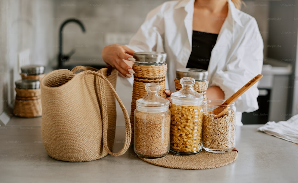 a woman standing in front of a counter filled with jars