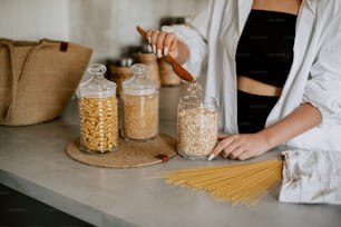 a woman in a black top is making pasta