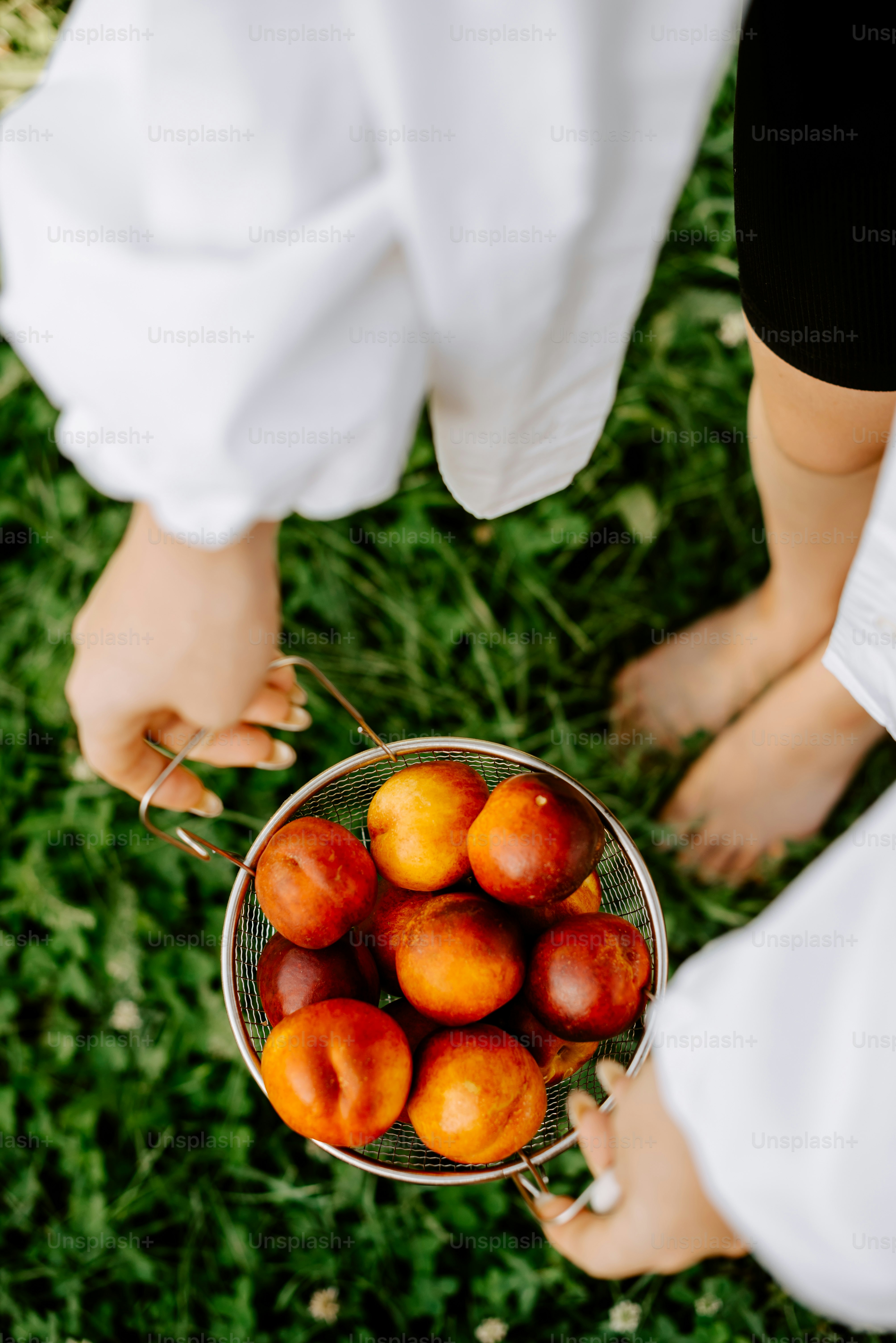 a person holding a bowl full of peaches
