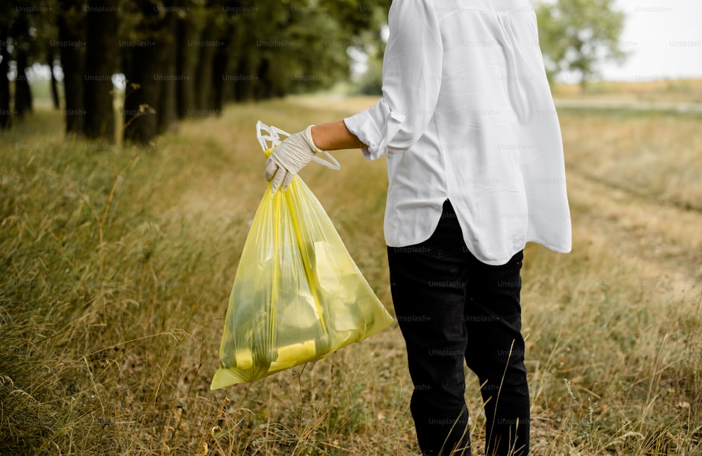 a man in a white shirt carrying a yellow bag