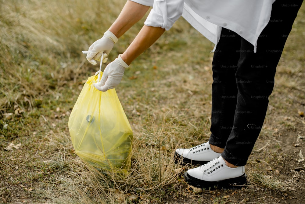 a person in white gloves holding a yellow bag
