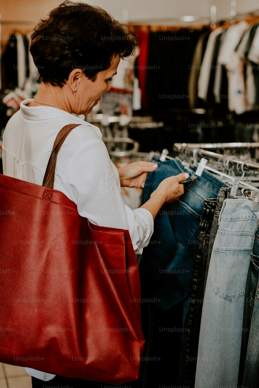 a woman is looking at a pair of jeans