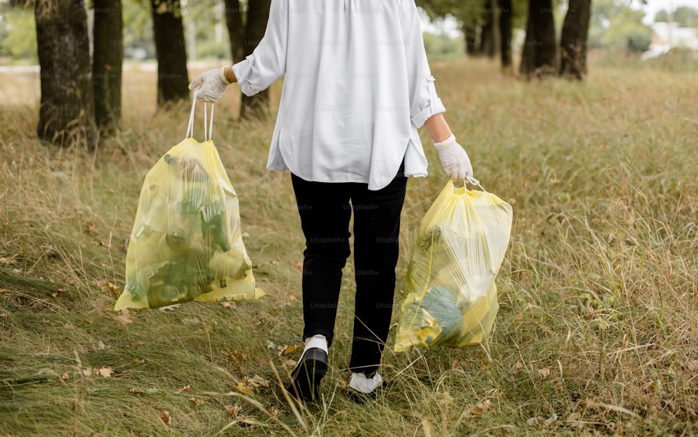 Une femme marchant dans un champ portant deux sacs