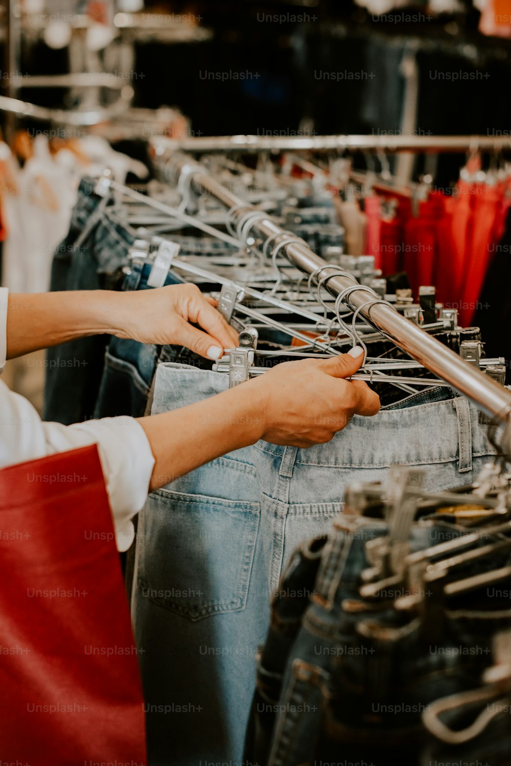 a person standing in front of a rack of jeans