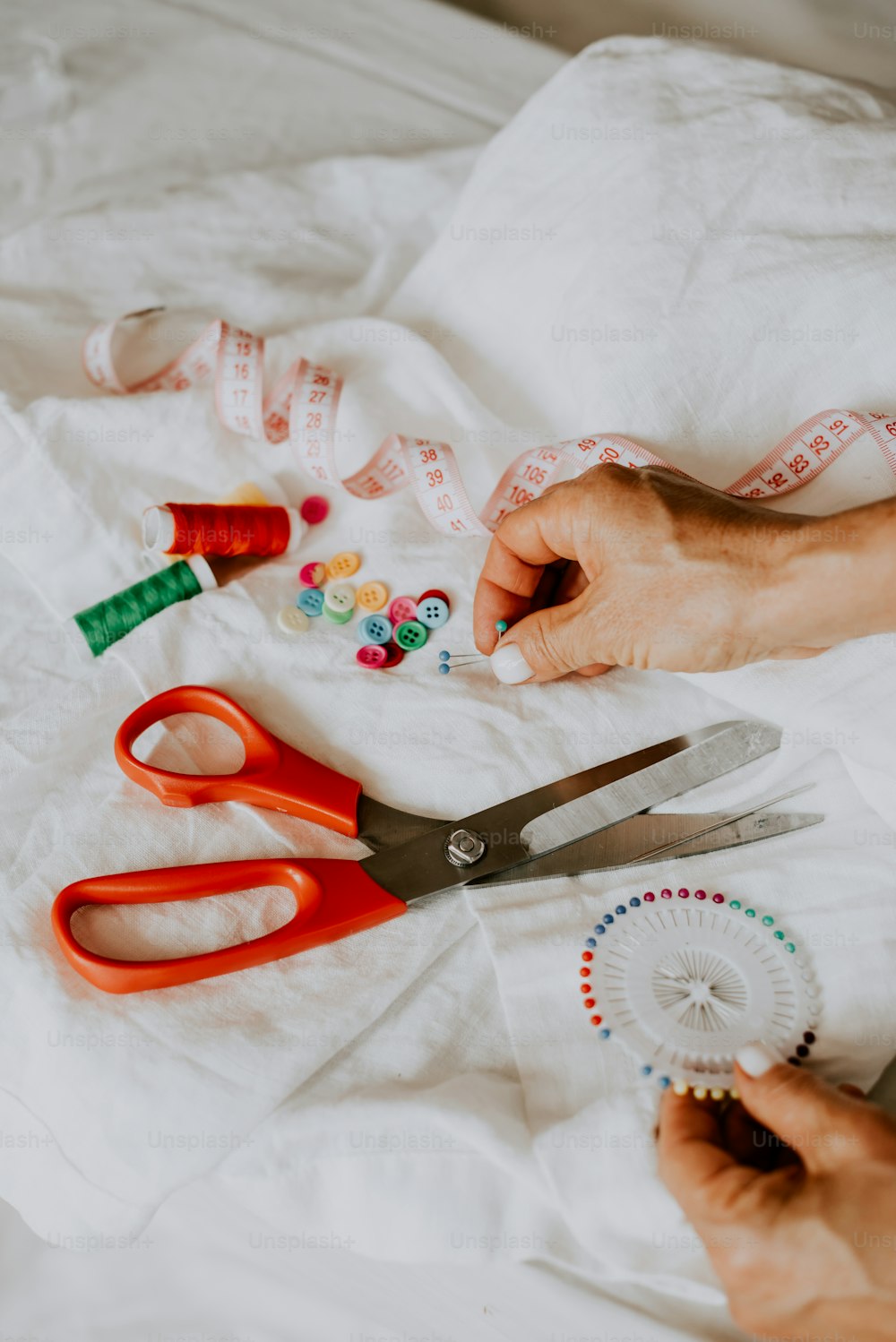 a pair of scissors and a tape measure on a bed