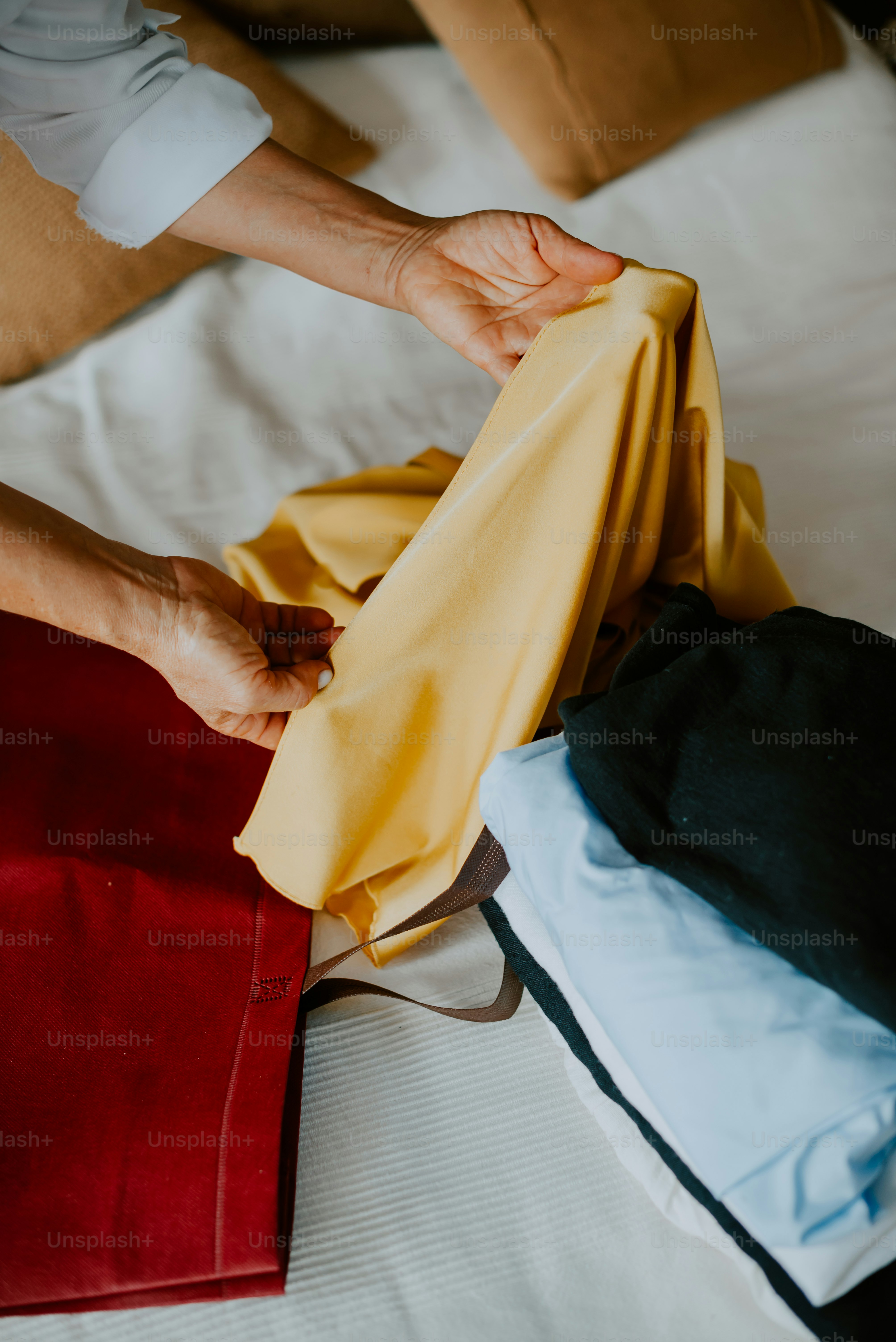 a person laying on top of a bed holding a yellow cloth