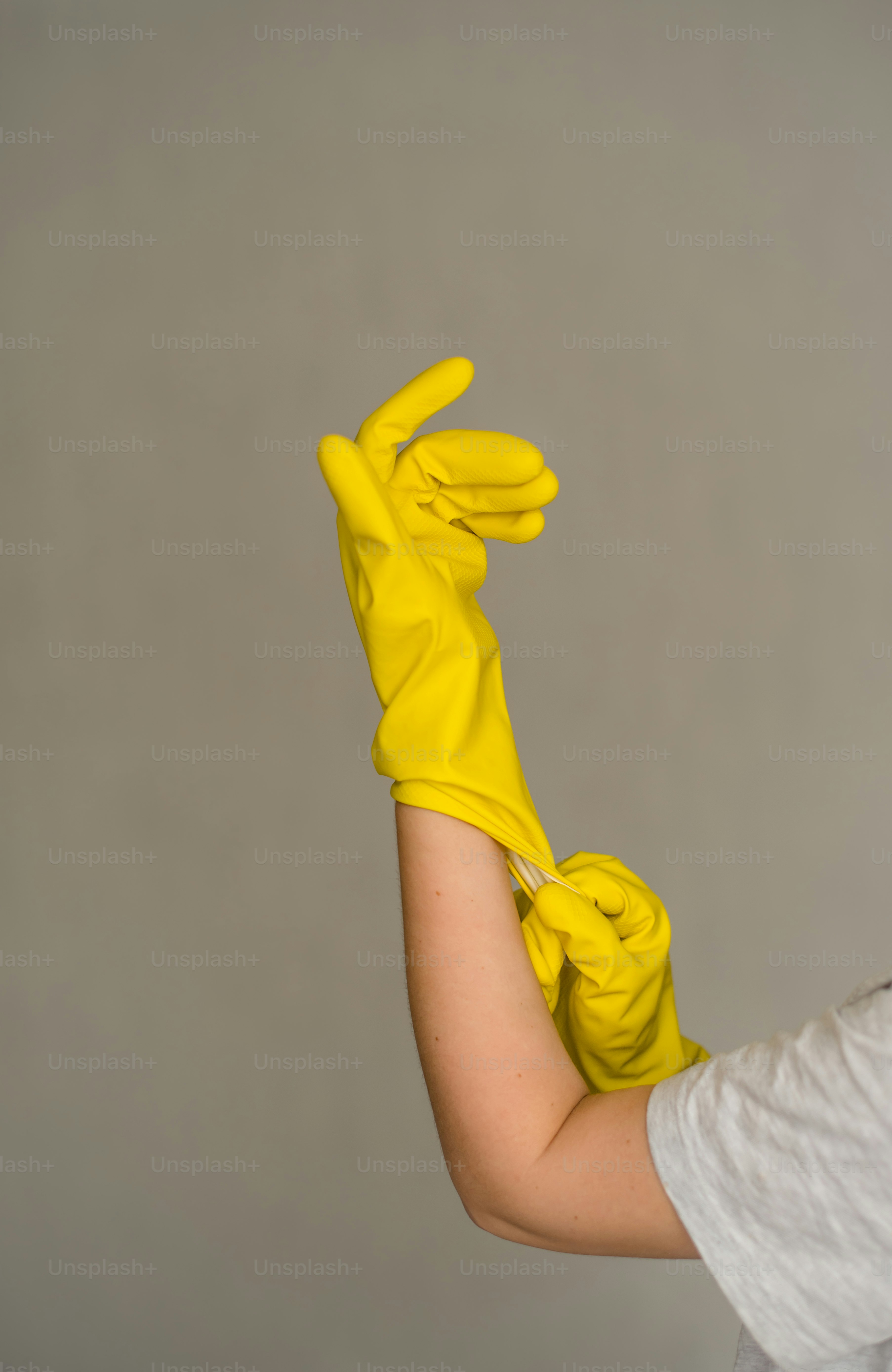 Una mujer con camisa blanca y guantes amarillos