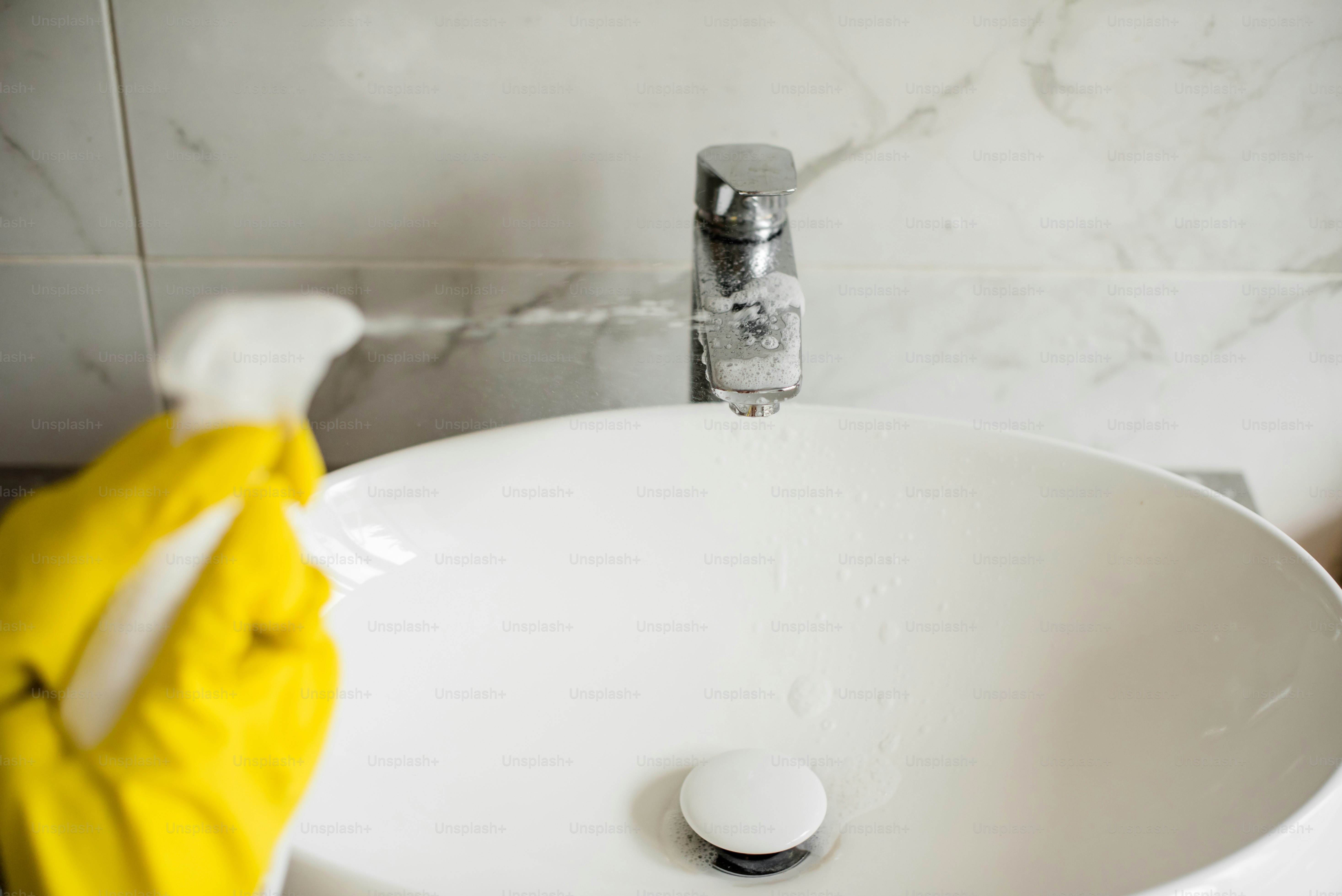 Un primer plano de un fregadero con un guante amarillo