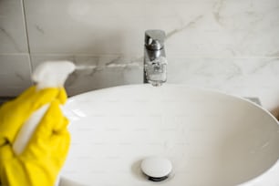 a close up of a sink with a yellow glove on it