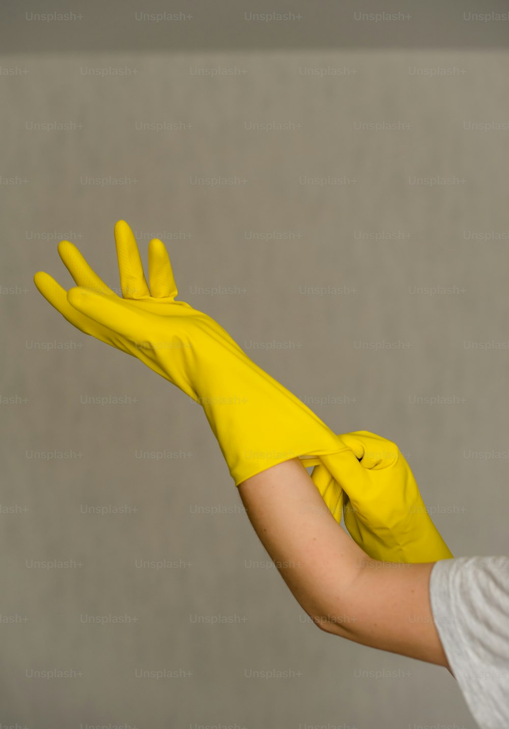 a woman wearing a yellow rubber glove