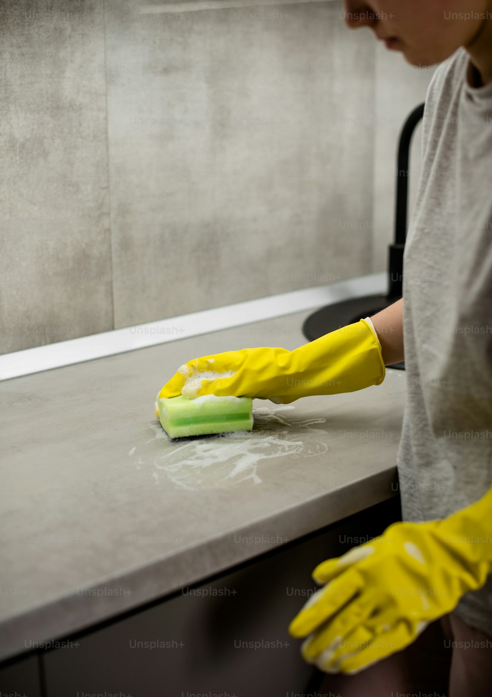 Una persona con guantes amarillos limpiando un mostrador