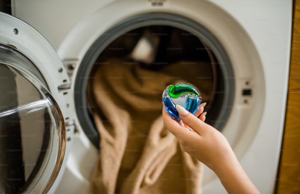 a woman is holding a toy in front of a washing machine