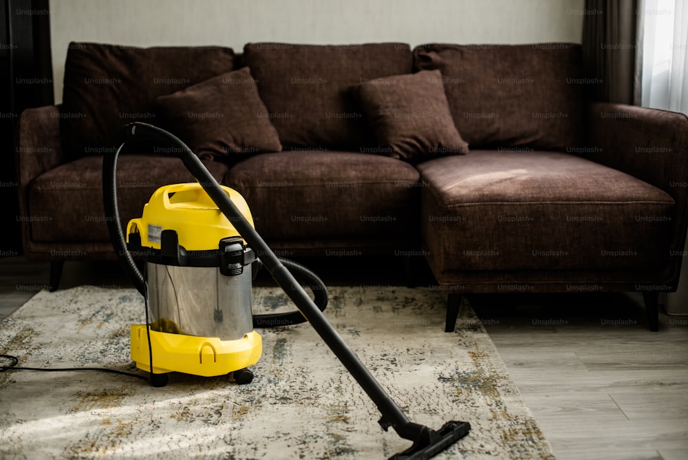 a yellow and black vacuum sitting on top of a rug
