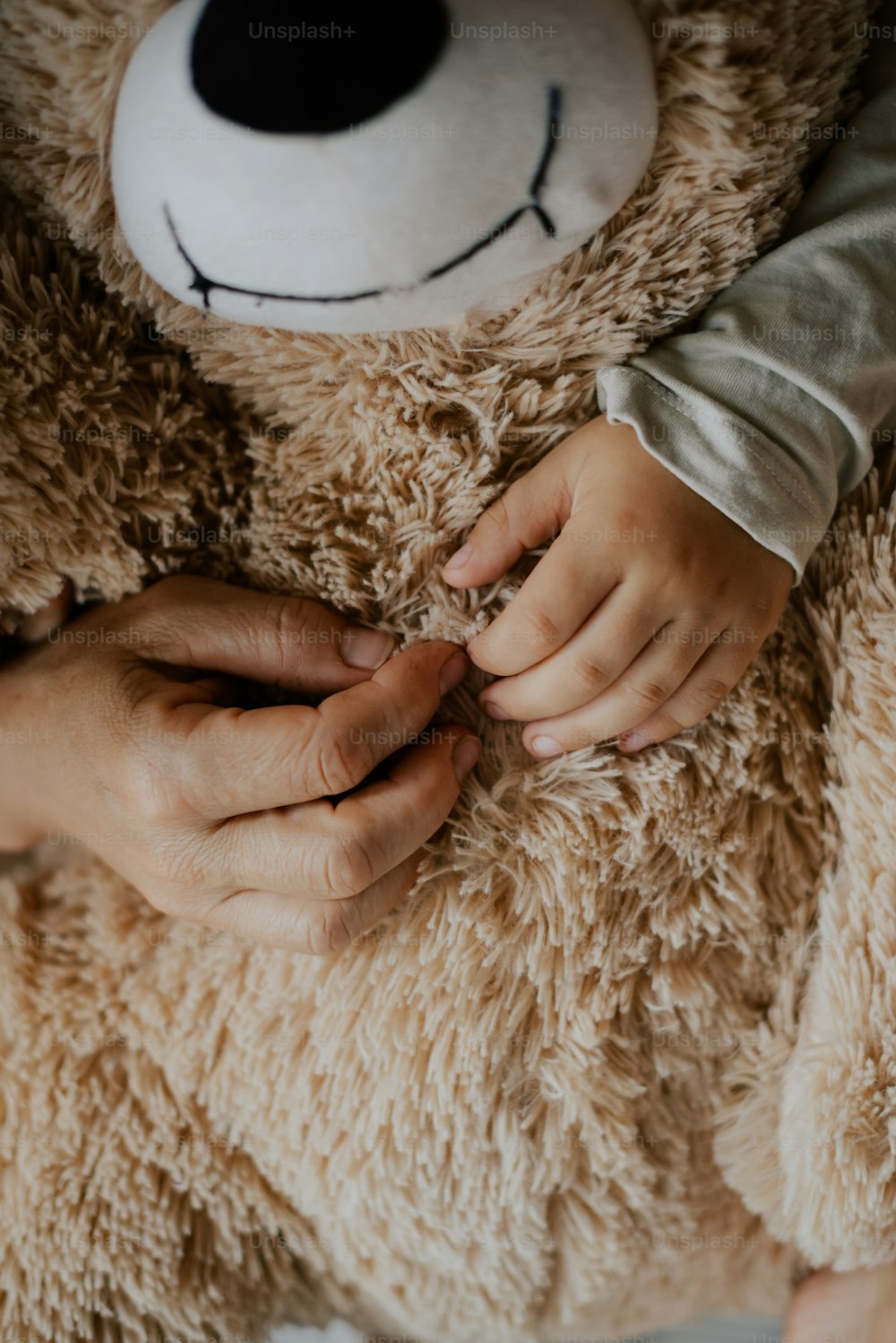 a person holding a teddy bear in their hands