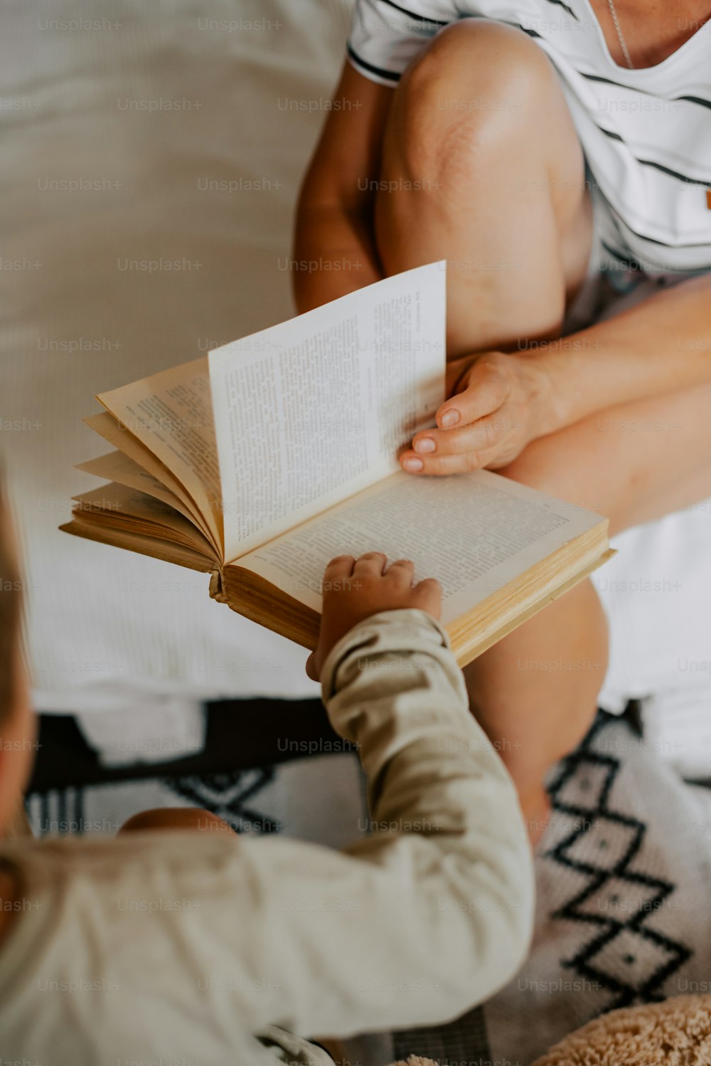 una donna che legge un libro a un bambino su un letto