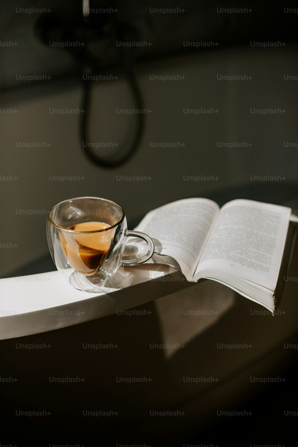 une tasse de thé et un livre ouvert sur une table