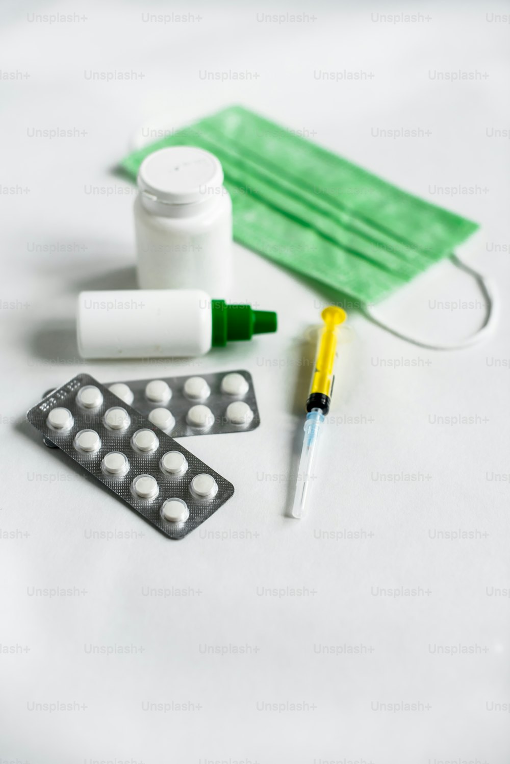 una mesa blanca cubierta con pastillas y un frasco de medicina