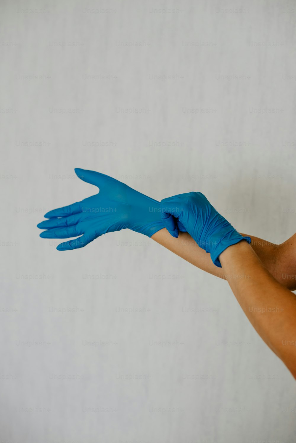 une personne avec des gants bleus sur les mains