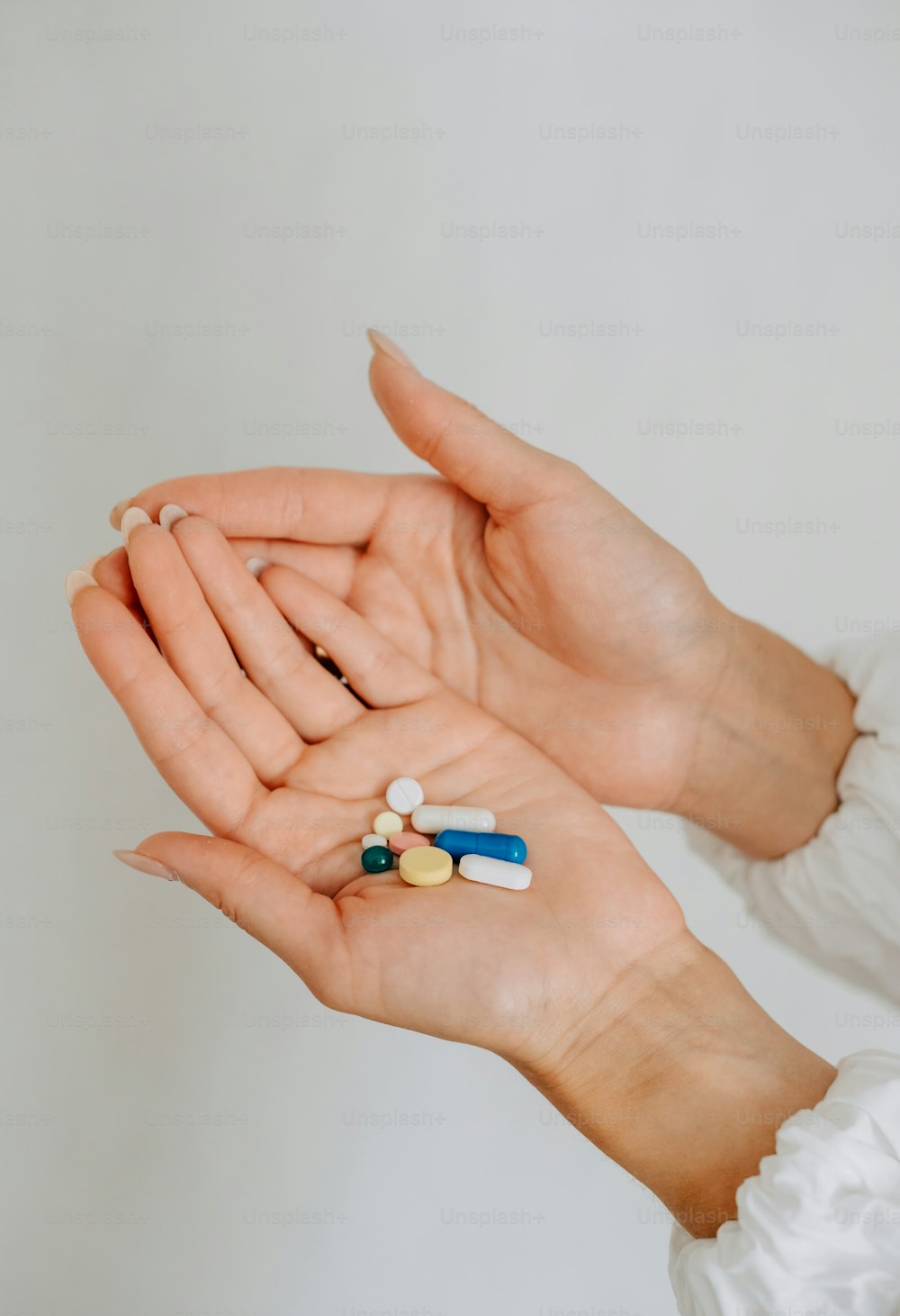 uma mulher segurando pílulas em suas mãos