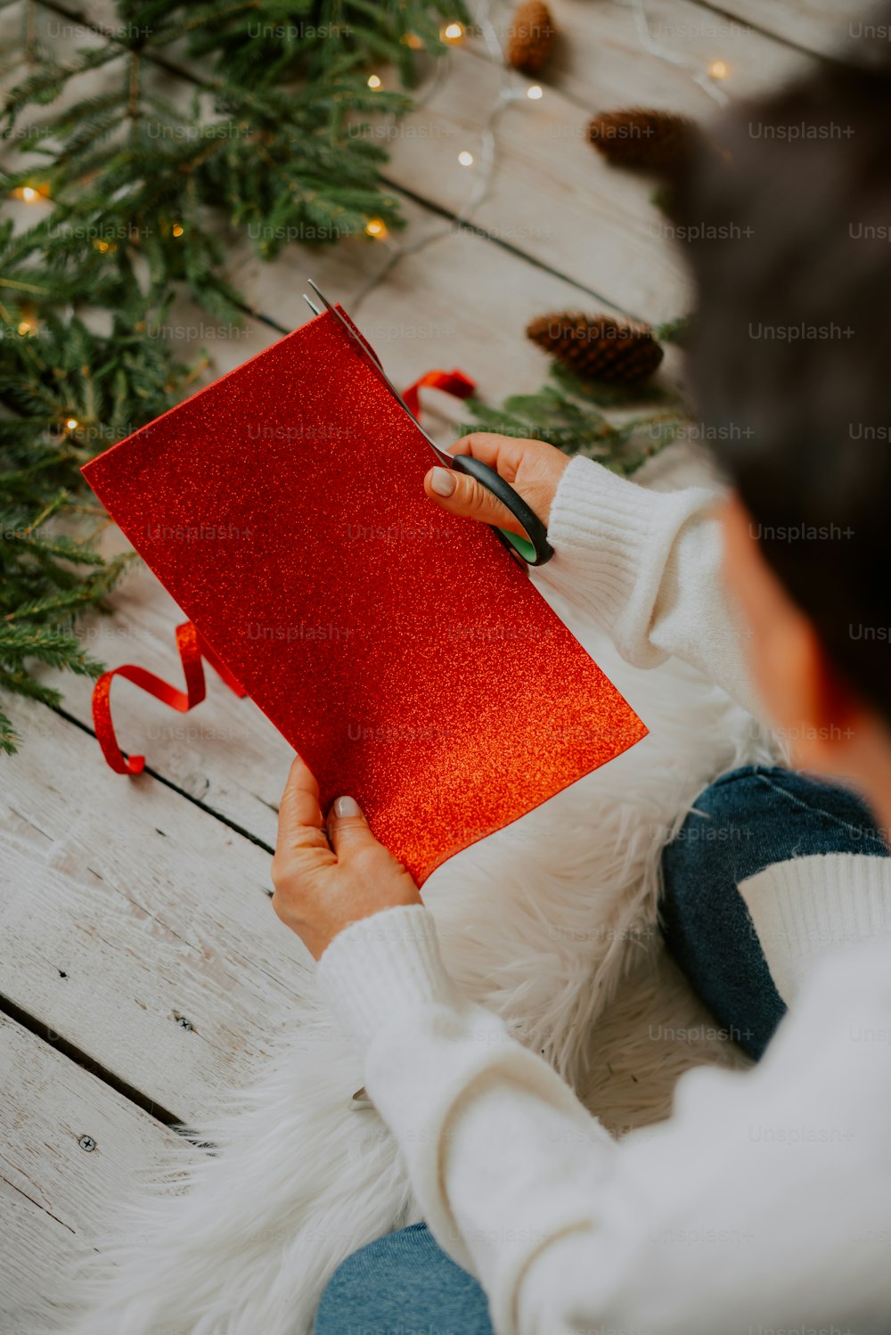 Ein Kind hält eine rote Weihnachtskarte in der Hand