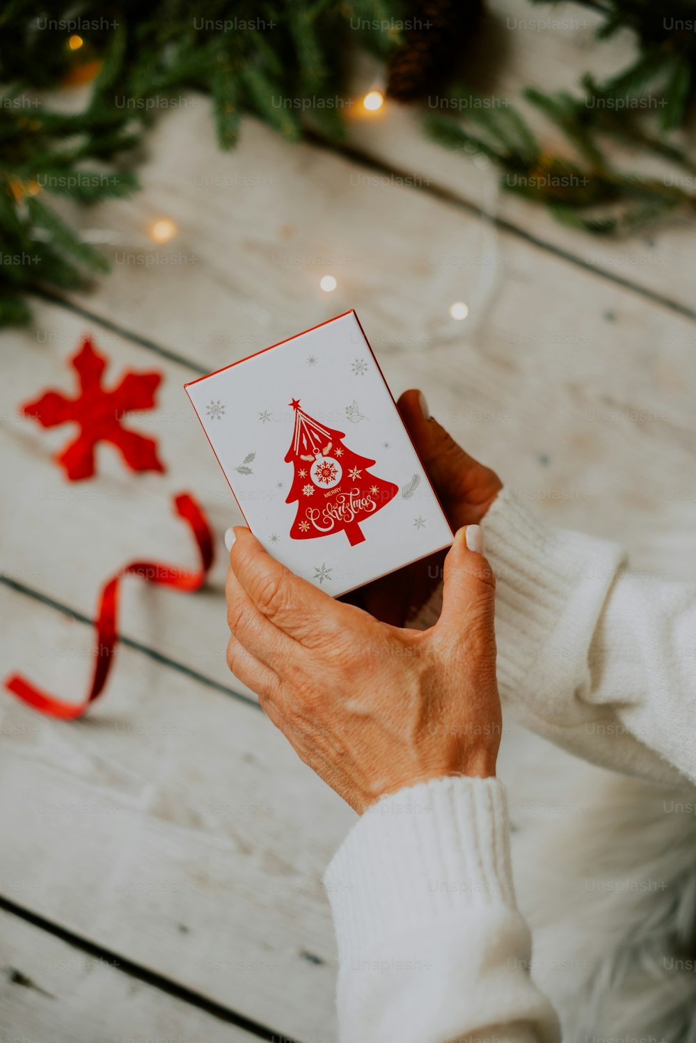 Una persona sosteniendo una tarjeta con un árbol de Navidad en ella