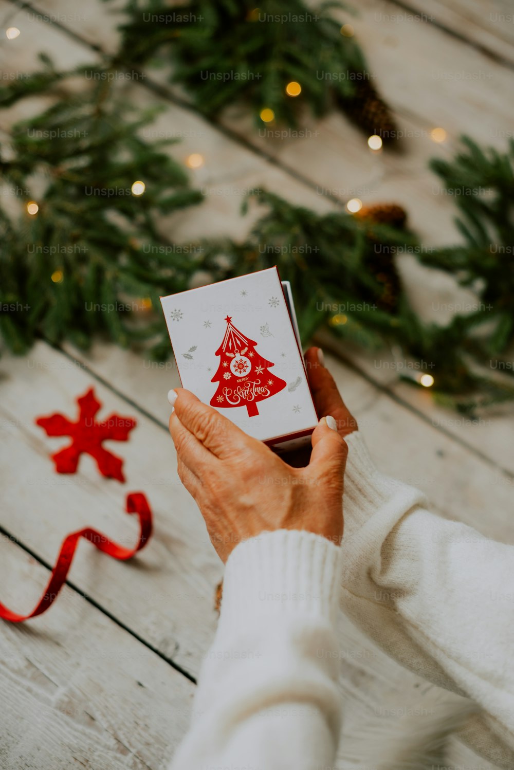 a person holding a card with a christmas tree on it